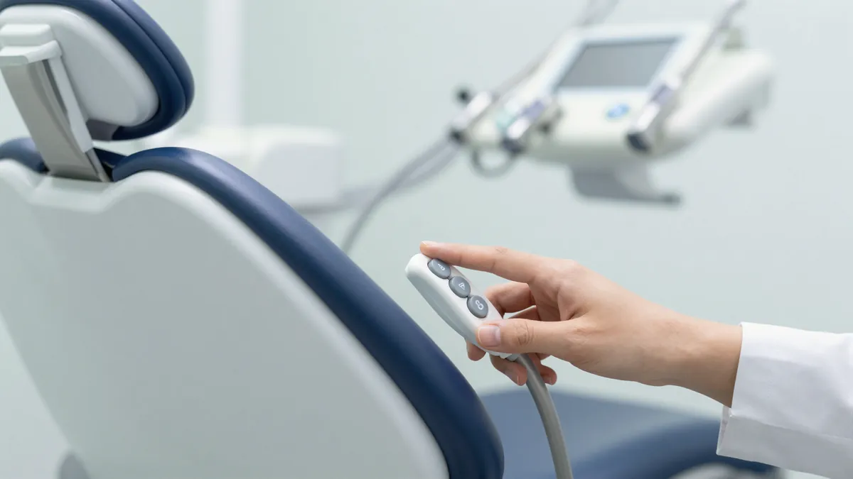 Dentist adjusting dental chair height with side control buttons